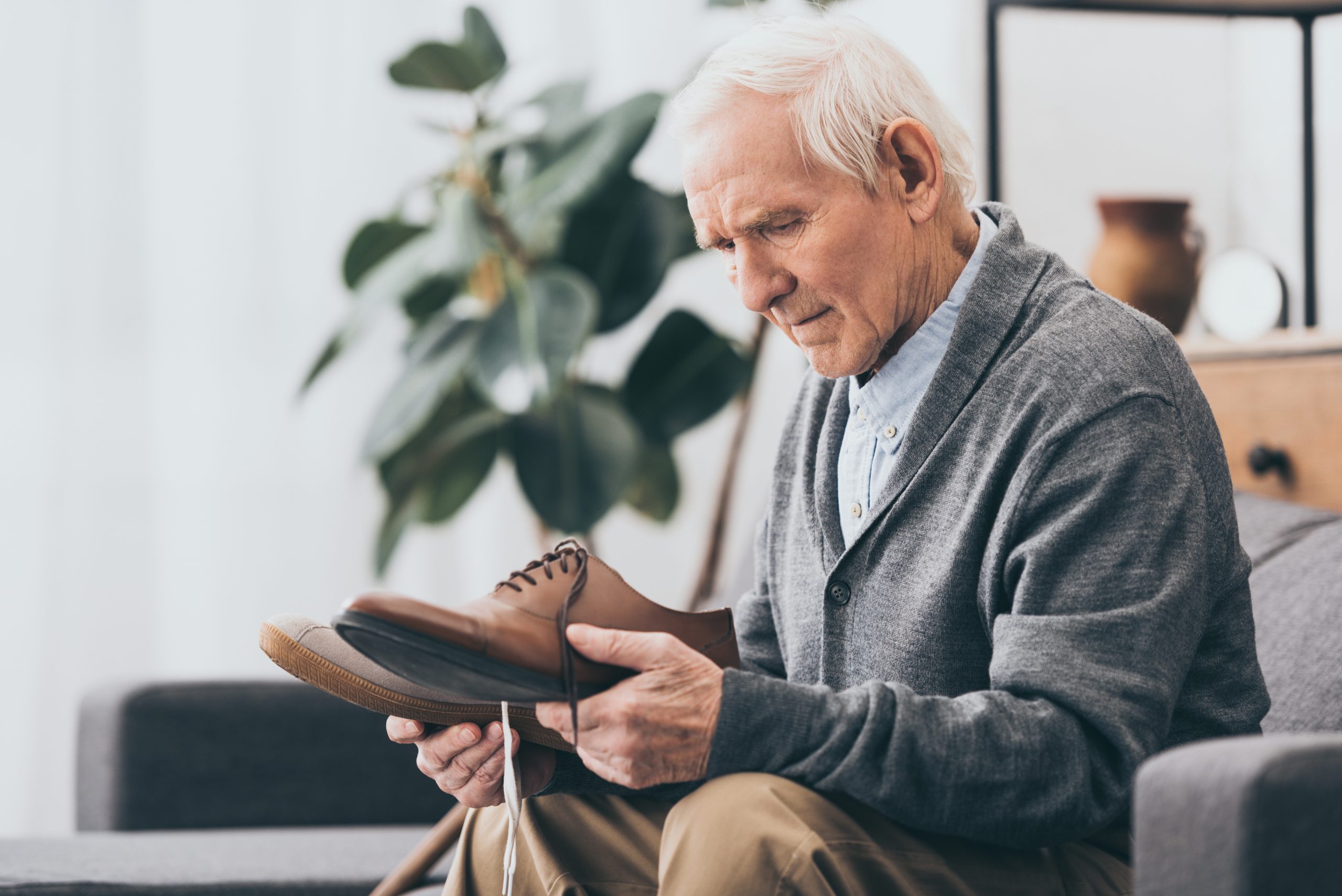 Senior man holding wide fitting comfort footwear shoe