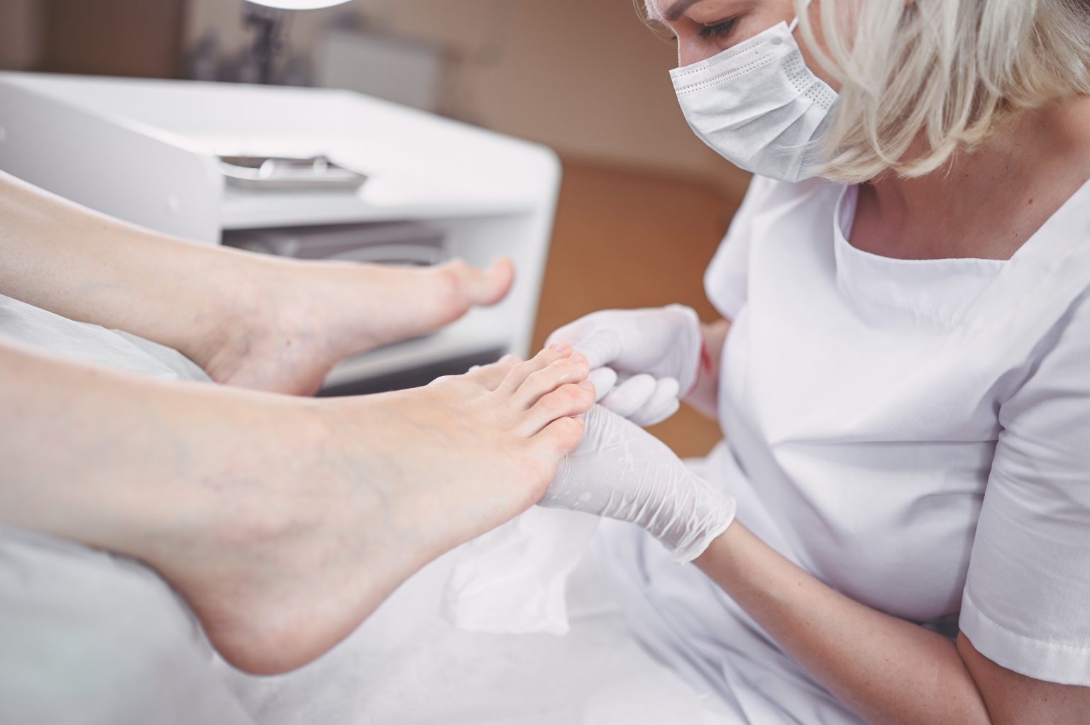 Pedicurist doing professional medical pedicure procedure in beauty